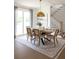 Bright dining room with a wood table, neutral chairs, and a statement light fixture at 1056 Capersview Ct, Awendaw, SC 29429