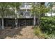 Ground level view of home's exterior, showcasing deck and landscaping at 1647 Live Oak Park, Seabrook Island, SC 29455