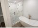 Bathroom with soaking tub, glass shower, and marble tile at 4504 Smoak Rd, Meggett, SC 29449