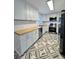 Modern kitchen with white cabinets, stainless steel appliances, and geometric patterned floor at 201 Josie Dr, Walterboro, SC 29488