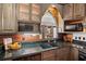 Kitchen features dark wood cabinets, granite countertops, and a farmhouse sink at 2773 Mt Carmel Rd, Walterboro, SC 29488