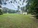 Large backyard with grassy area and a yellow house at 422 Constance St, Walterboro, SC 29488