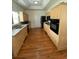 Kitchen with light wood cabinets, hardwood floors and black appliances at 422 Constance St, Walterboro, SC 29488