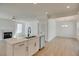 Modern kitchen features a large island, white cabinets, and hardwood floors at 2193 Blue Bayou Blvd, Johns Island, SC 29455