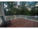 Deck overlooking a wooded backyard with rocking chair at 6949 Maybank Hwy, Wadmalaw Island, SC 29487