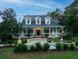 Two-story home with wrap-around porch, fountain, and landscaping at 6949 Maybank Hwy, Wadmalaw Island, SC 29487