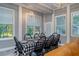 Sunroom dining area with a black and white checkered tablecloth and ample seating at 6949 Maybank Hwy, Wadmalaw Island, SC 29487