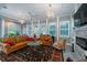 Sunroom with leather sofas, a fireplace, and plenty of natural light at 6949 Maybank Hwy, Wadmalaw Island, SC 29487