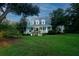 Two-story home with wrap-around porch and fountain at 6949 Maybank Hwy, Wadmalaw Island, SC 29487