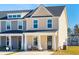 Two-story tan townhome with a front porch, gray trim and a two-car driveway at 229 Abercom Place Dr, Moncks Corner, SC 29461