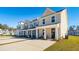 Row of townhomes with front porches, landscaping, and individual driveways at 229 Abercom Place Dr, Moncks Corner, SC 29461