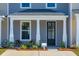 Inviting exterior featuring a covered porch, gray siding, and landscaping at 205 Abercom Place Dr, Moncks Corner, SC 29461