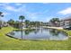 Community pond with lush landscaping and palm trees at 100 Mariners Cay Dr, Folly Beach, SC 29439