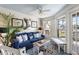 Bright sunroom with a blue couch, white trim, and access to a patio at 1637 Live Oak Park, Seabrook Island, SC 29455