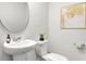 Small bathroom with white sink, toilet, and a round mirror at 1020 Lovebug Ln, Summerville, SC 29485