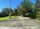 Long concrete driveway leading to a home with mature trees on either side at 1229 Central Ave, Summerville, SC 29483