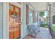 Inviting front door and porch with metal bench and tile floor at 380 Ashley Ave, Charleston, SC 29403