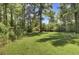 Spacious backyard with lush greenery and a fire pit at 1586 Highway 15, Saint George, SC 29477