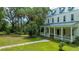 Charming two-story home featuring a spacious front porch and lush landscaping at 8083 Point Of Pines Rd, Edisto Island, SC 29438