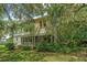 White two-story house with wrap around porch, screened porch and mature trees at 8083 Point Of Pines Rd, Edisto Island, SC 29438