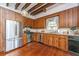 Kitchen with wood cabinets, stainless steel appliances, exposed beams, hardwood floors at 8083 Point Of Pines Rd, Edisto Island, SC 29438