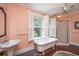 Classic bathroom with clawfoot tub, shower, and hardwood floors at 8083 Point Of Pines Rd, Edisto Island, SC 29438