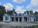 Newly constructed home showcasing a white exterior, black metal roof, and front porch at 210 Oyster Catcher Ln, Ravenel, SC 29470
