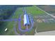 Aerial view of a modern equestrian barn with a surrounding riding track at 210 Oyster Catcher Ln, Ravenel, SC 29470