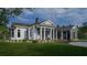 White two-story house with a large front porch and landscaped yard at 210 Oyster Catcher Ln, Ravenel, SC 29470