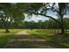 Long country road with trees and wooden fence leading through the property at 210 Oyster Catcher Ln, Ravenel, SC 29470