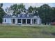 White farmhouse with a dark metal roof and landscaping at 210 Oyster Catcher Ln, Ravenel, SC 29470
