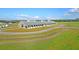 An expansive equestrian barn with a curved driveway and wooden fence at 210 Oyster Catcher Ln, Ravenel, SC 29470