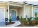 Front porch with blue door, two chairs, and landscaping at 386 Tupelo Lake Dr, Summerville, SC 29486