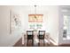 Bright dining room with white table and chairs, wood floors, and modern light fixture at 366 Wappoo Trace Ln, Summerville, SC 29486