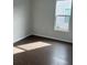Simple bedroom with hardwood floors and large window at 741 Blue Iris Way, Summerville, SC 29486