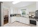 White kitchen with stainless steel appliances and view to dining area at 5 Avon Ct, Charleston, SC 29407