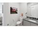 Stylish half bathroom with a dark vanity, patterned floor, and flamingo art at 301 Longshore St # 441, Charleston, SC 29492