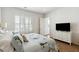 Bright bedroom with a queen bed, white shutters, and a flat-screen TV at 301 Longshore St # 441, Charleston, SC 29492