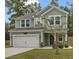 Two-story house with green siding, white garage door, and landscaping at 316 Bay Village Ln, Moncks Corner, SC 29461