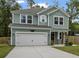 Two-story house with green siding, white garage door, and landscaping at 316 Bay Village Ln, Moncks Corner, SC 29461