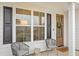 Charming front porch with gray wicker chairs, a wooden door, and black shutters at 416 Grove End Rd, Moncks Corner, SC 29461