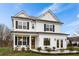 Two story white farmhouse style home with black shutters and a welcoming front porch at 416 Grove End Rd, Moncks Corner, SC 29461
