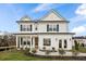 Two story white farmhouse style home with black shutters and a welcoming front porch at 416 Grove End Rd, Moncks Corner, SC 29461