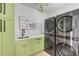 Bright laundry room with stylish green cabinets and high-end LG washer and dryer at 228 Haddrell St, Mount Pleasant, SC 29464