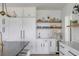 White kitchen with built-in shelving, marble countertops, and gold fixtures at 228 Haddrell St, Mount Pleasant, SC 29464
