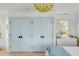 Bright bedroom with built-in light blue closet doors and hardwood floors at 228 Haddrell St, Mount Pleasant, SC 29464