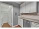 White shaker cabinets, granite countertops, and access to laundry at 1443 Cambridge Lakes Dr, Mount Pleasant, SC 29464