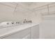 Bright laundry room with Whirlpool washer and dryer and ample shelving at 1443 Cambridge Lakes Dr, Mount Pleasant, SC 29464