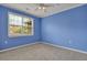 Bright bedroom featuring a large window, grey carpet, and blue walls at 1443 Cambridge Lakes Dr, Mount Pleasant, SC 29464