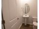 Small bathroom with pedestal sink, toilet, and oval mirror at 217 Pink Azalea St, Summerville, SC 29485